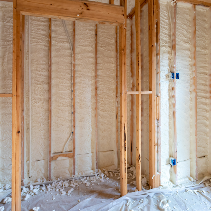 Spray foam insulation inside wooden wall framing.