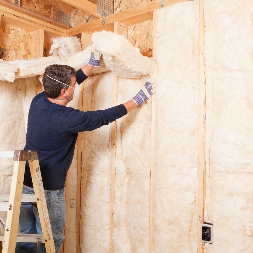 man putting up insulation in a dallas home